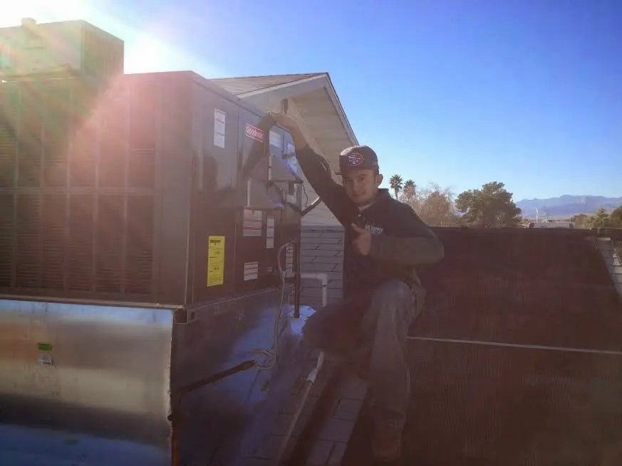 HVAC technician performing Boiler Repair on a rooftop unit in Des Moines